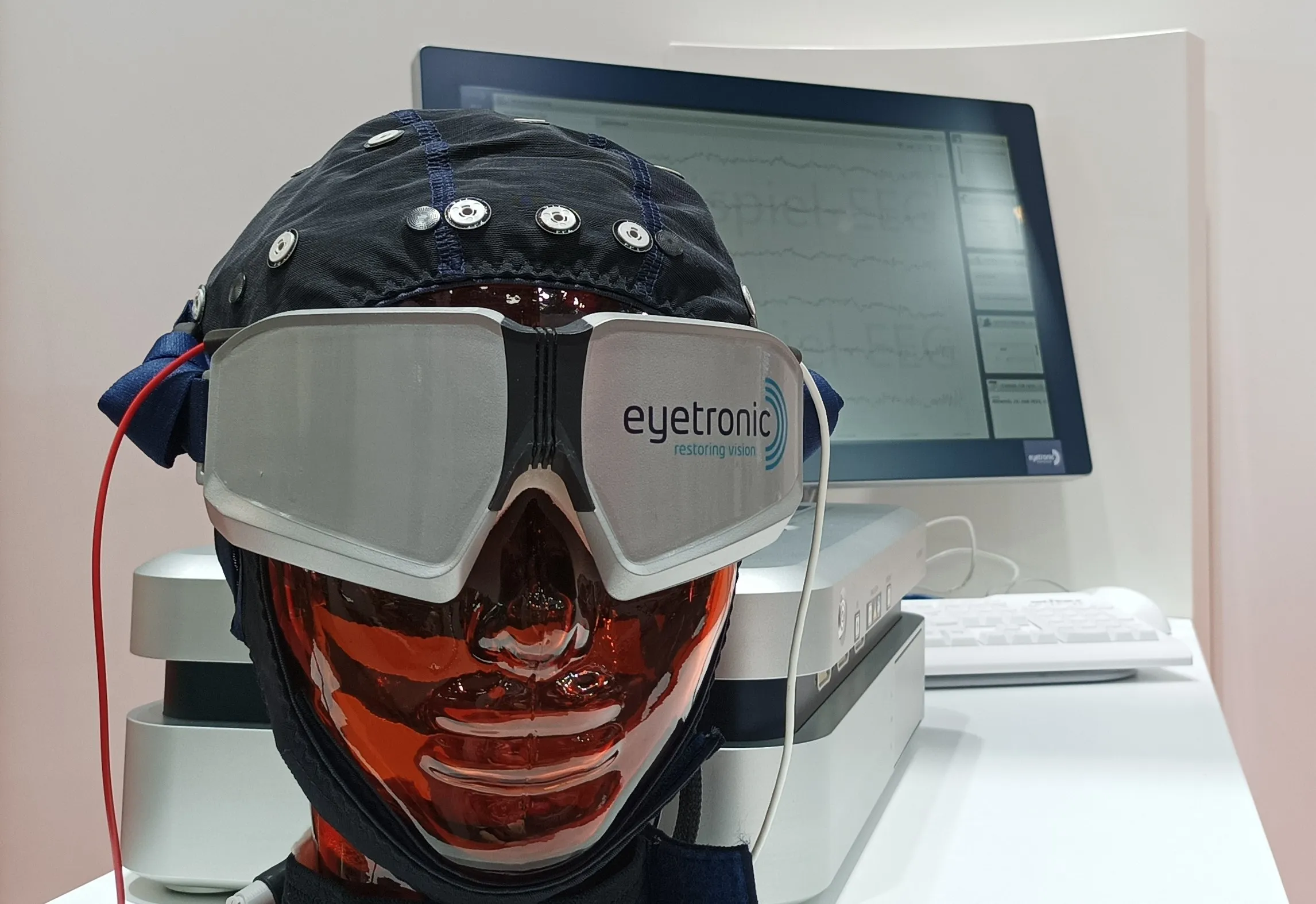 Prístroj Eyetronic — elektródová čiapka a okuliare na modeli hlavy